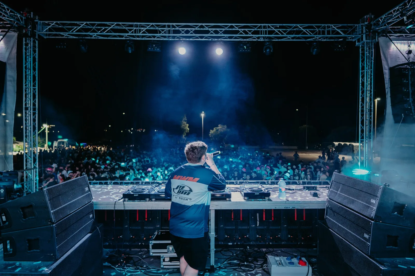 DJ de LoVasAVivir de espaldas frente al público de una plaza